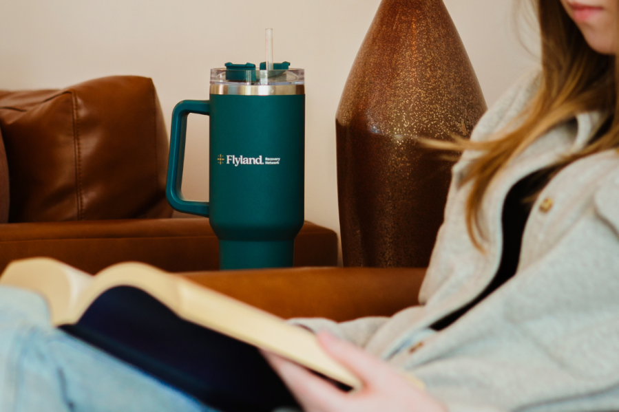 Methamphetamine addiction flyland A person in recovery from methamphetamine addiction reading a book while drinking from a Flyland cup